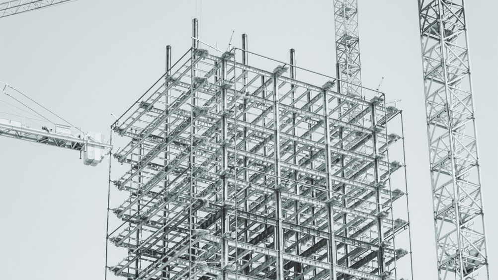 Multi-story building construction site, demonstrating the benefits of BIM in the construction industry. The benefits of BIM for the main contractor mean they experience earlier problem identification, reduced risk, lower costs, improved sustainability, and enhanced project planning and management. Main contractors can leverage the power of BIM to enhance collaboration, safety, sustainability, and competitiveness.