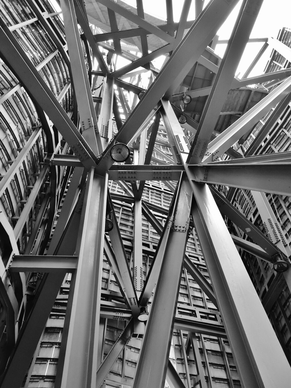 Black and white shot of metal structures in a large-scale construction project as seen from below