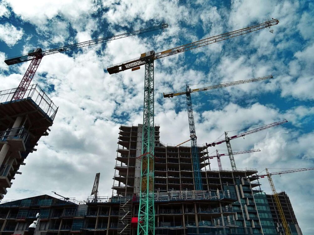 BIM-coordinated high-rise construction project with cranes and scaffolding